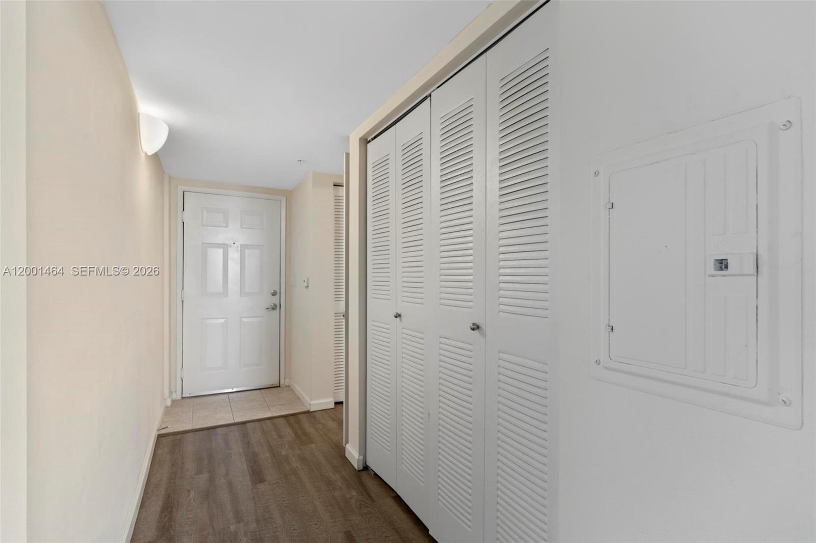 An entryway features a white door, louvered closet doors, and wood-look flooring — 1919 Van Buren St # 417A, Hollywood FL 33020, HOLLYWOOD, FL