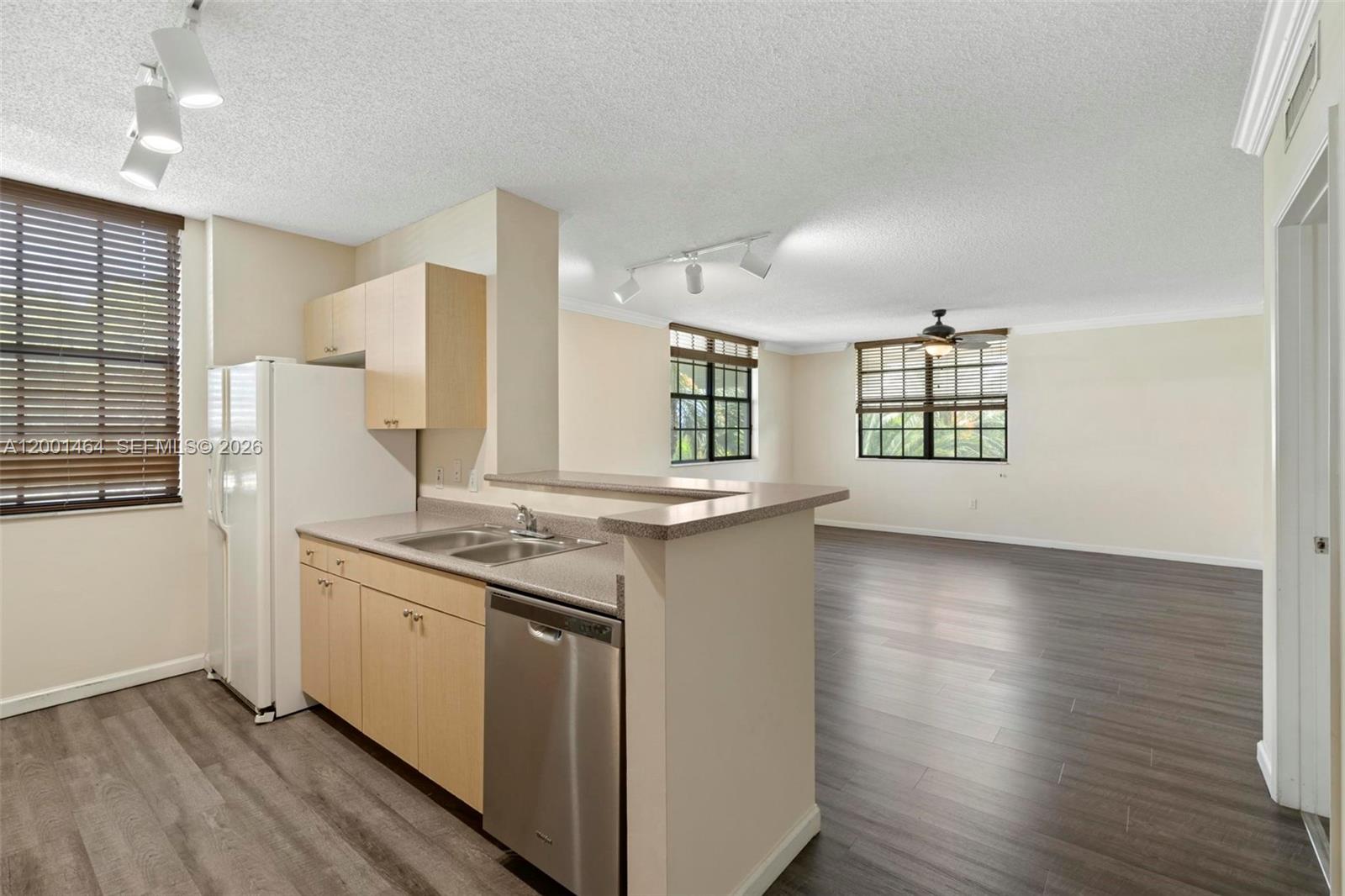 A kitchen with light wood cabinets and stainless steel appliances opens to a living area — 1919 Van Buren St # 417A, Hollywood FL 33020, HOLLYWOOD, FL