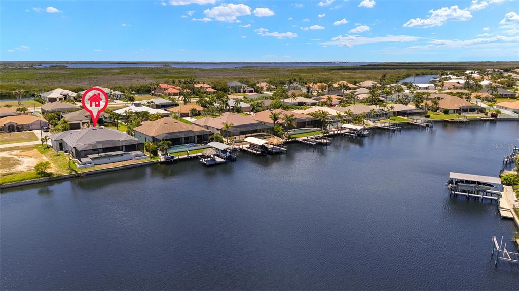 An aerial view shows a waterfront house with a pool and dock along a canal — 3123 SW 29TH AVENUE, CAPE CORAL, FL