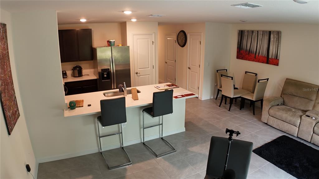 An open-concept kitchen with a breakfast bar, stainless steel appliances, and an adjacent dining area — 6569 SW 81ST LOOP, OCALA, FL