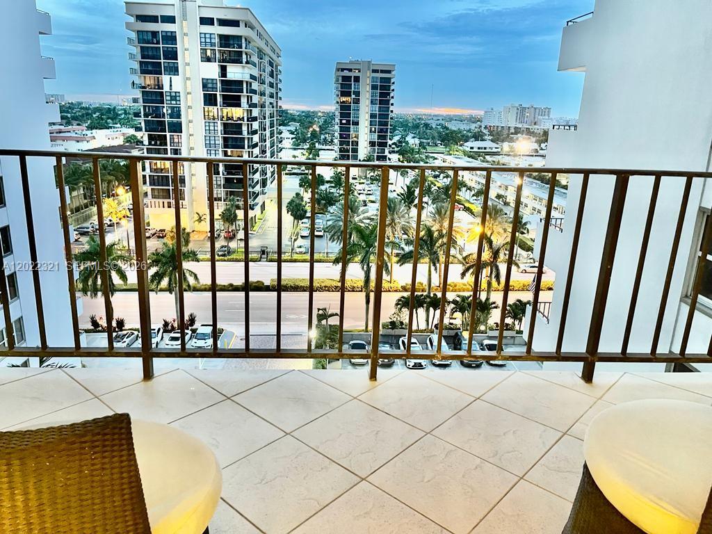 A balcony with tiled flooring overlooks a parking lot and tall residential buildings — 2030 S Ocean Dr # 801, Hallandale Beach FL 33009, HALLANDALE BEACH, FL