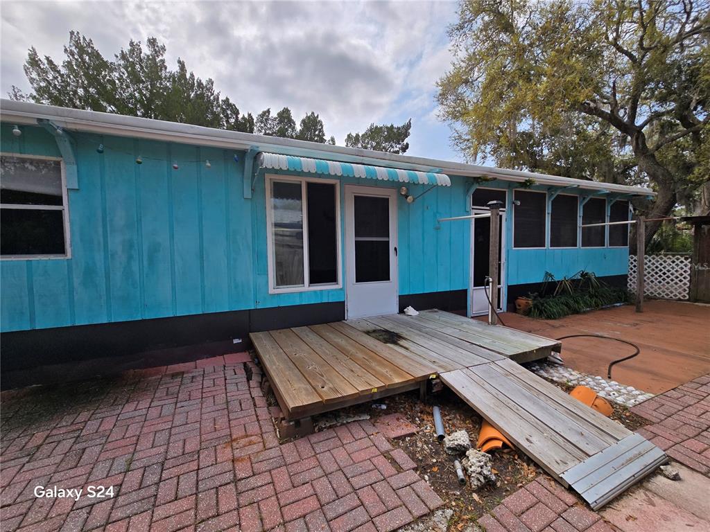 The exterior of a blue mobile home features a wooden deck and a ramp — 14365 & 14353 W EBBTIDE COURT, CRYSTAL RIVER, FL