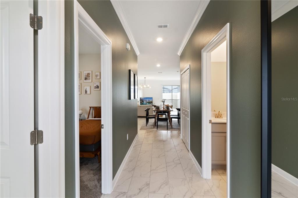 A hallway with tile flooring leads to a dining area and living room — 4184 PARAGRAPH DRIVE, KISSIMMEE, FL