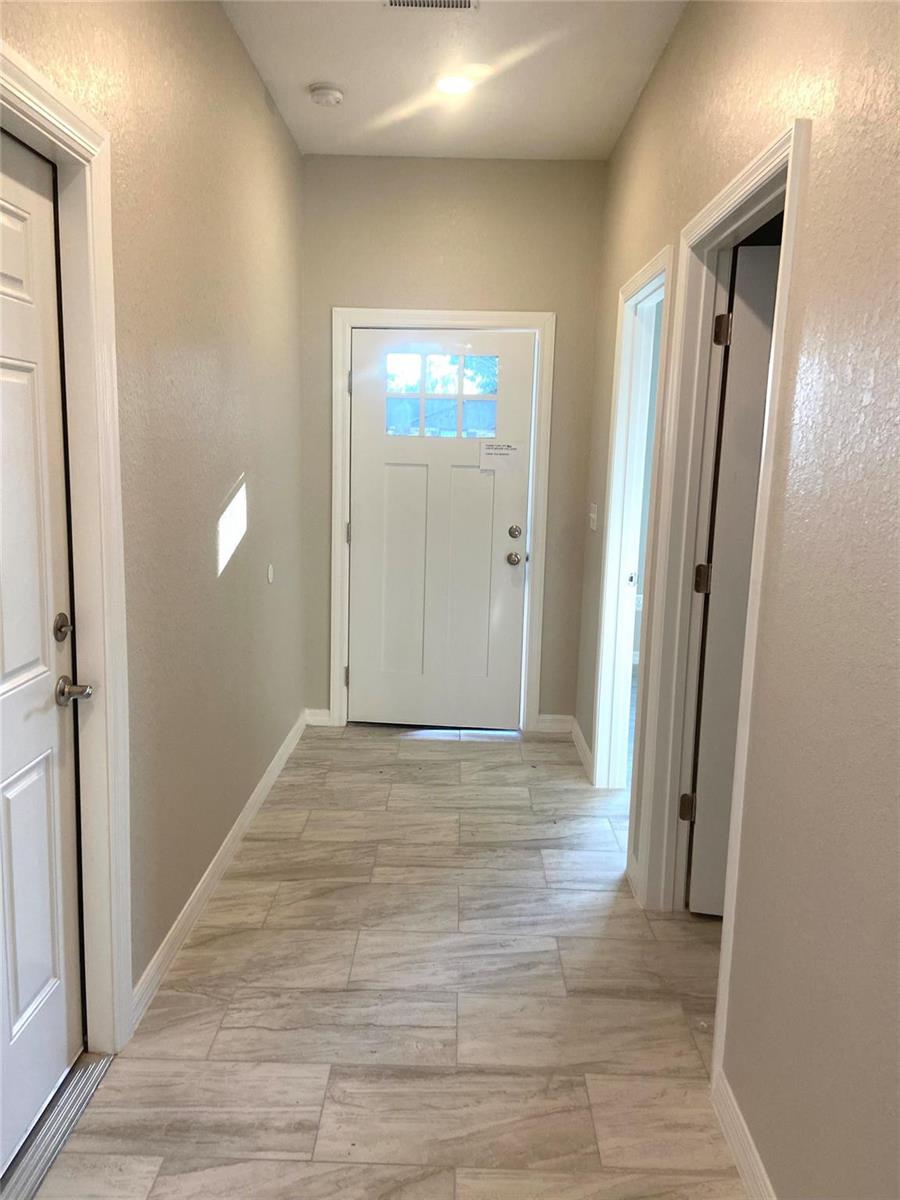 A bright entryway features light-colored tile flooring, beige walls, and a white front door — 4229 Elson Avenue, Sebring FL 33875, SEBRING, FL