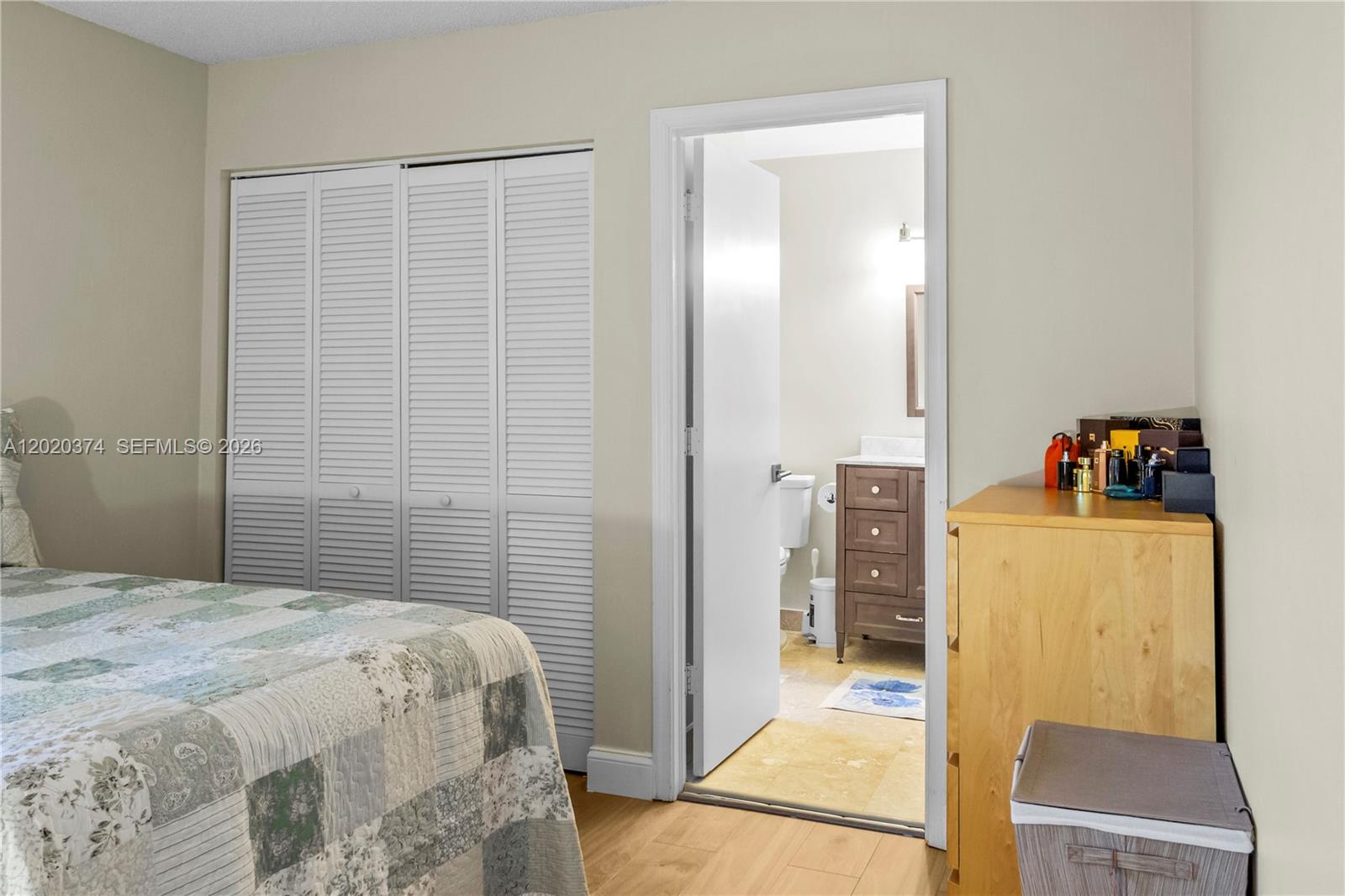 A bedroom features a bed, louvered closet doors, and an open doorway to a bathroom — 6885 NW 75th Pl, Parkland FL 33067, PARKLAND, FL