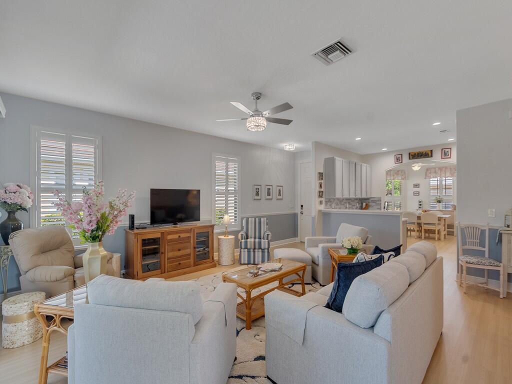 A living room features light gray walls, a ceiling fan, and an open-concept kitchen beyond — 7780 14th Lane, Vero Beach FL 32966, VERO BEACH, FL