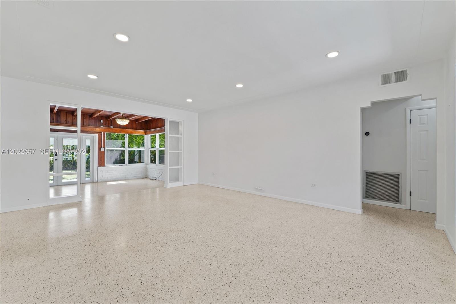 A spacious living room with white walls, recessed lighting, and light-colored speckled flooring — 8927 Carlyle Ave, Surfside FL 33154, SURFSIDE, FL