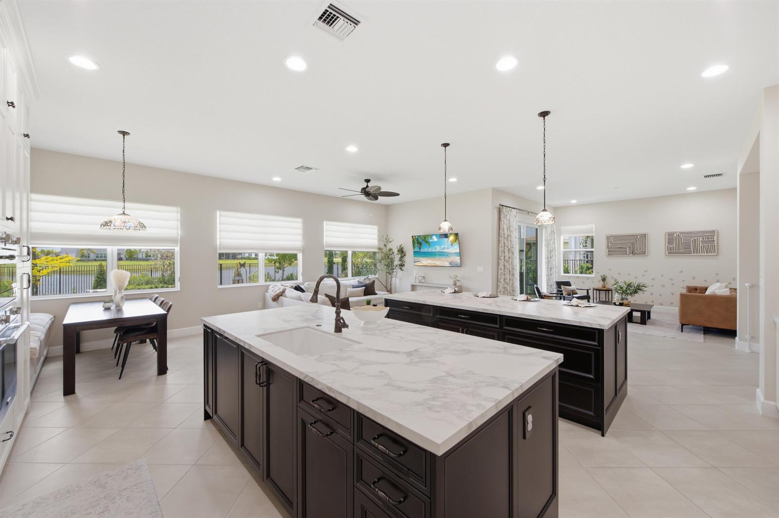 A kitchen features two large islands with dark cabinets and white marble countertops — 14160 Lacebark Lane, Westlake FL 33470, WESTLAKE, FL