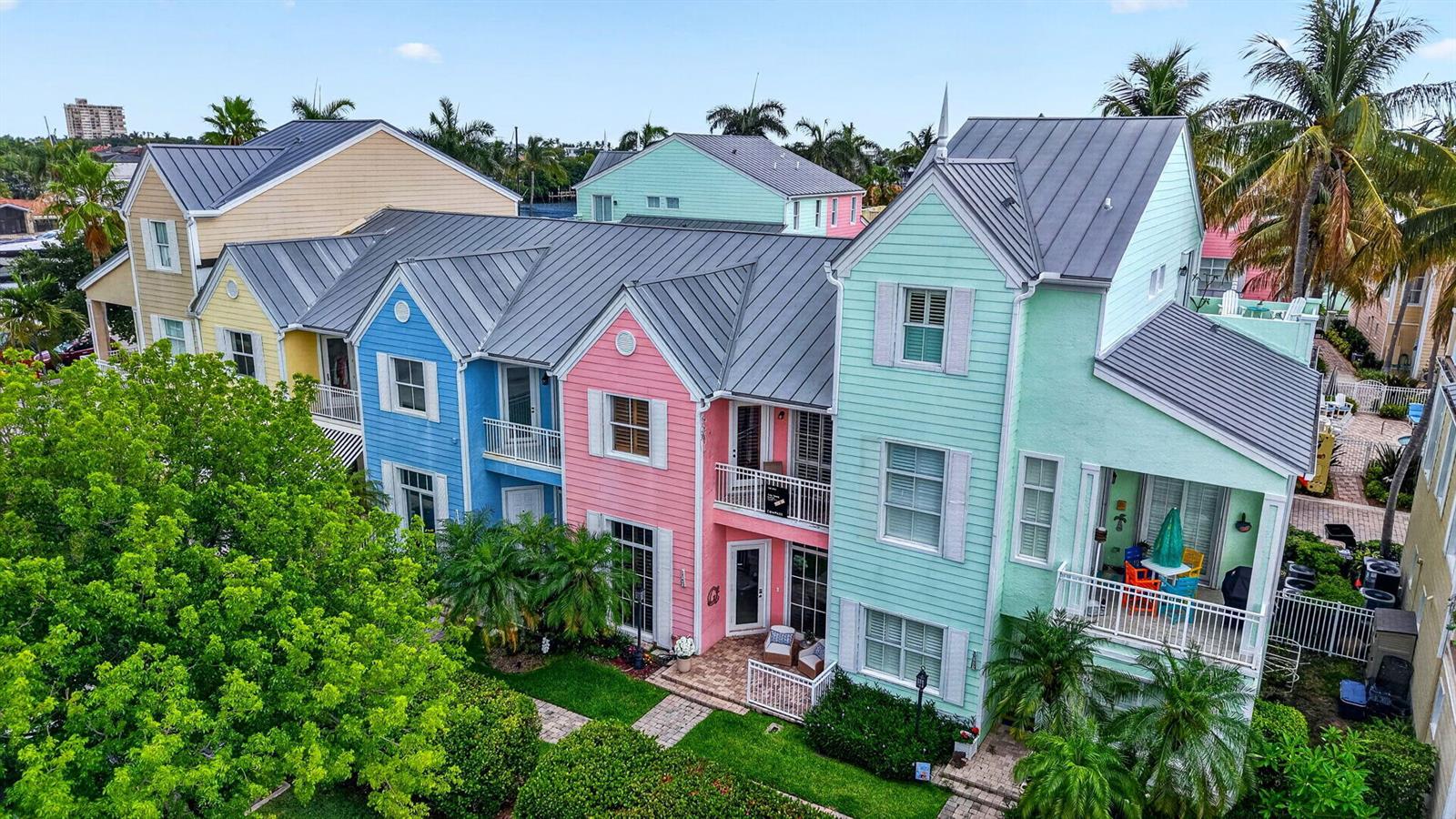 An aerial view of a row of colorful, multi-story townhouses with metal roofs and balconies — 2860 Marina Circle, Lighthouse Point FL 33064, LIGHTHOUSE POINT, FL