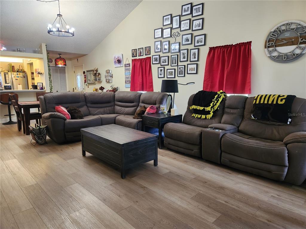 A living room features a large sectional sofa, a coffee table, and a gallery wall — 1701 SE 24TH ROAD UNIT 1601, OCALA, FL