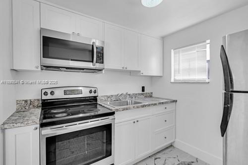 A kitchen featuring white cabinets, stainless steel appliances, and a window above the sink — 54 NW 62nd St # 4, Miami FL 33150, MIAMI, FL