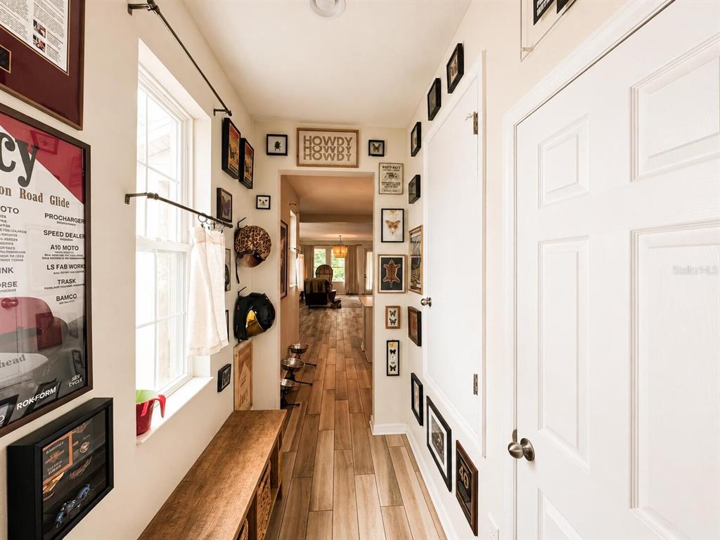 A kitchen features light-colored cabinetry, stainless steel appliances, a central island, and wood-look flooring — 1463 SOURWOOD DRIVE, OCOEE, FL