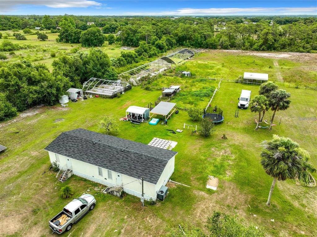 An aerial view shows a single-story house, several outbuildings, and a large yard with trees — 3345 RAMBLER AVENUE, ST CLOUD, FL
