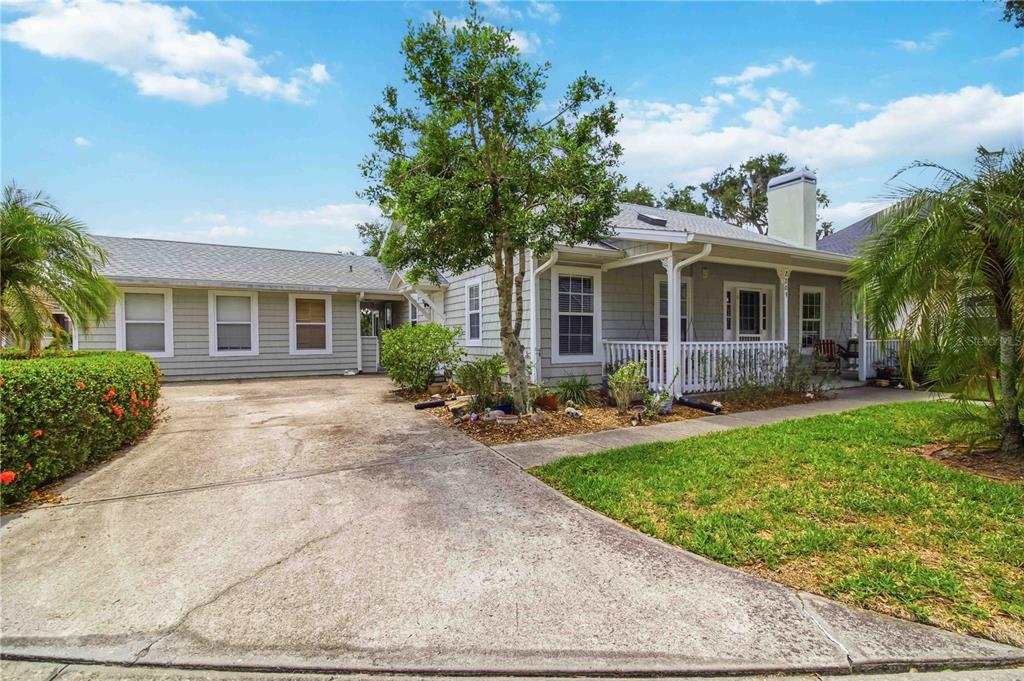 A single-story house with gray siding, a concrete driveway, and a front porch — 2209 68TH DRIVE E, ELLENTON, FL
