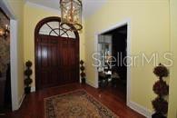 An entryway features a wooden double door, a hanging lantern, and yellow walls — 8475 NE 16TH TERRACE, OCALA, FL