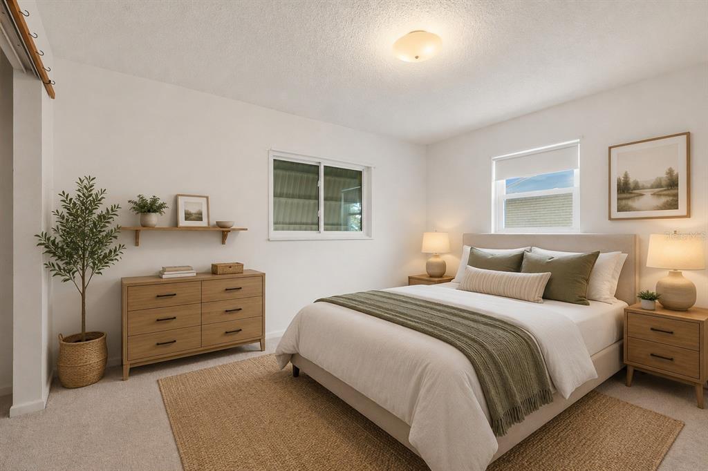 A bedroom features a bed with green bedding, a wooden dresser, and a jute rug — 6130 17TH STREET, ZEPHYRHILLS, FL