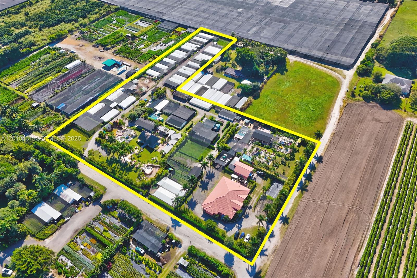 This aerial view shows a residential property with multiple structures and greenhouses outlined in yellow — 20455 SW 154th Ave, Miami FL 33187, MIAMI, FL