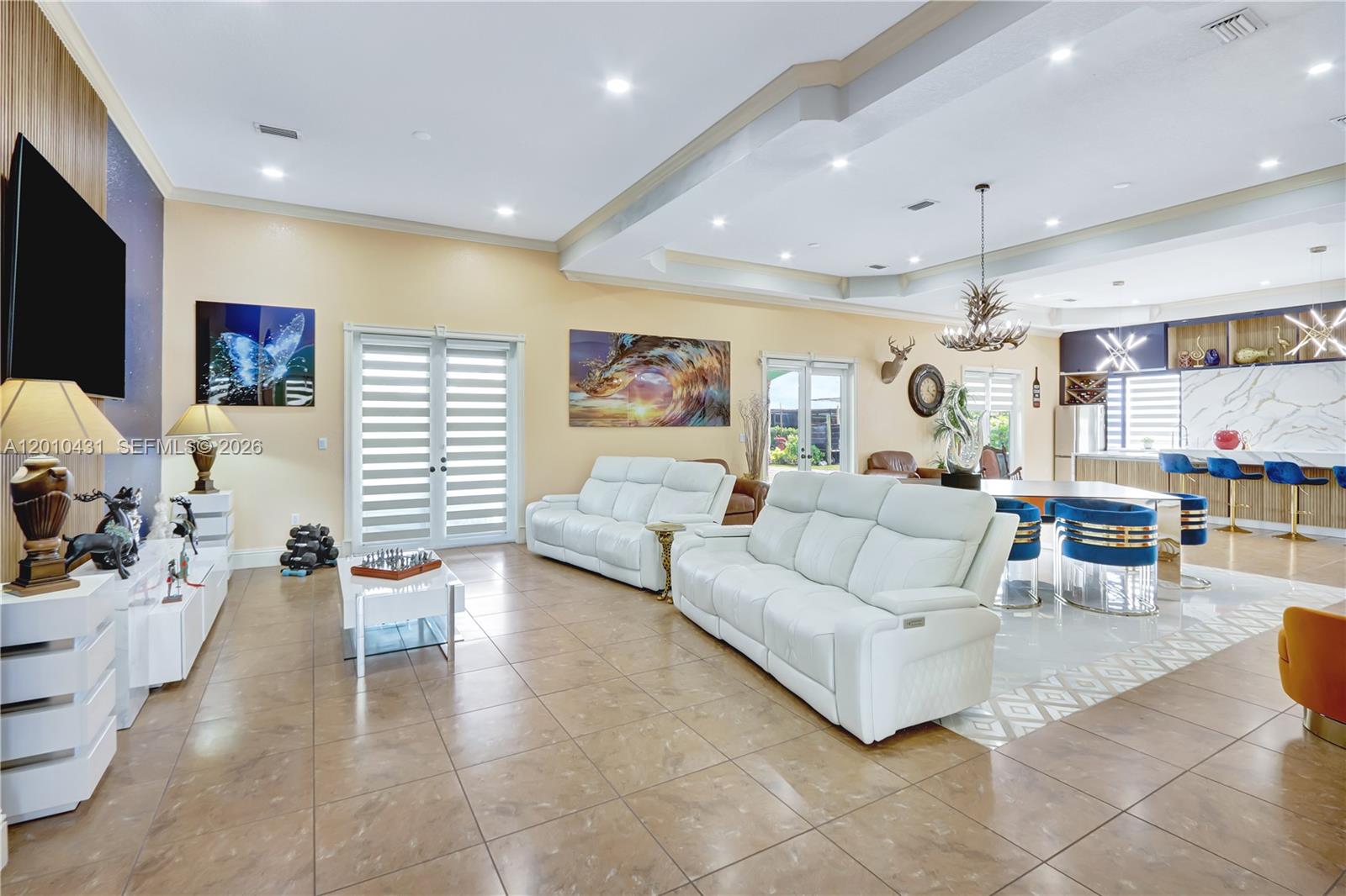 A spacious open-concept living room features white leather sofas, tile flooring, and a kitchen island — 20455 SW 154th Ave, Miami FL 33187, MIAMI, FL