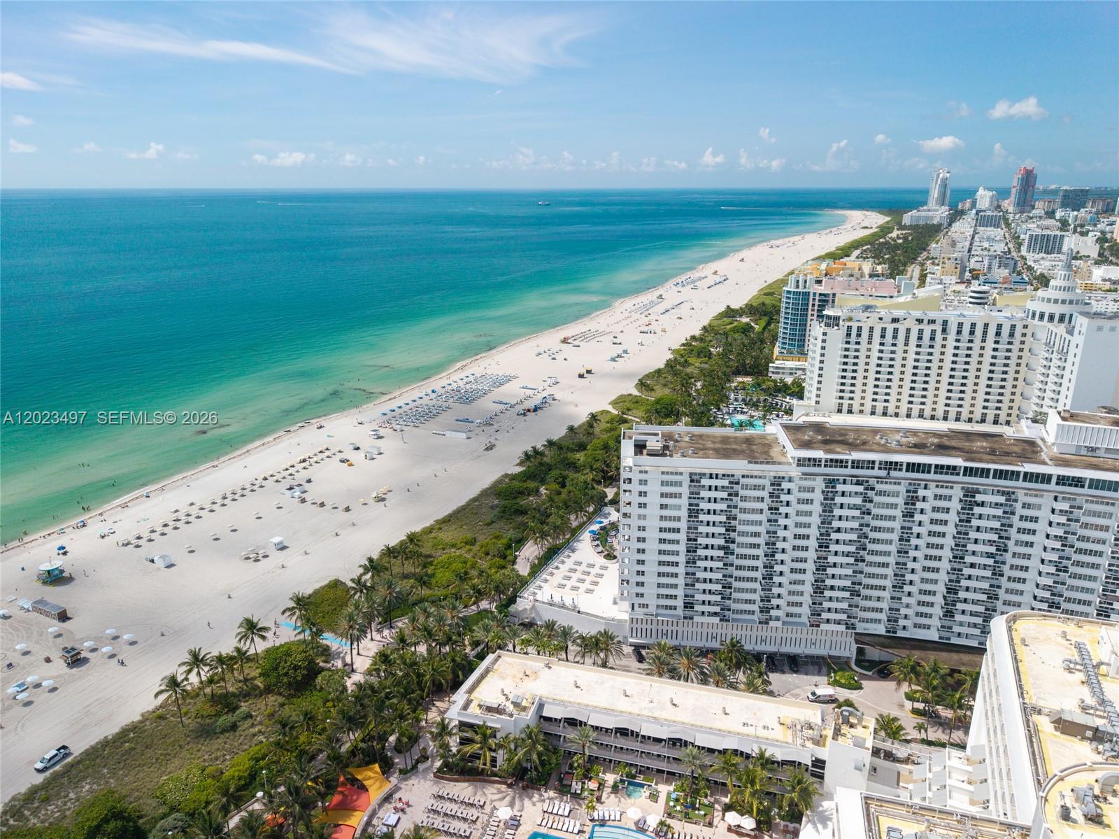 An aerial view shows a sandy beach, turquoise ocean, and several high-rise resort buildings — 100 Lincoln Rd # 1523, Miami Beach FL 33139, MIAMI BEACH, FL