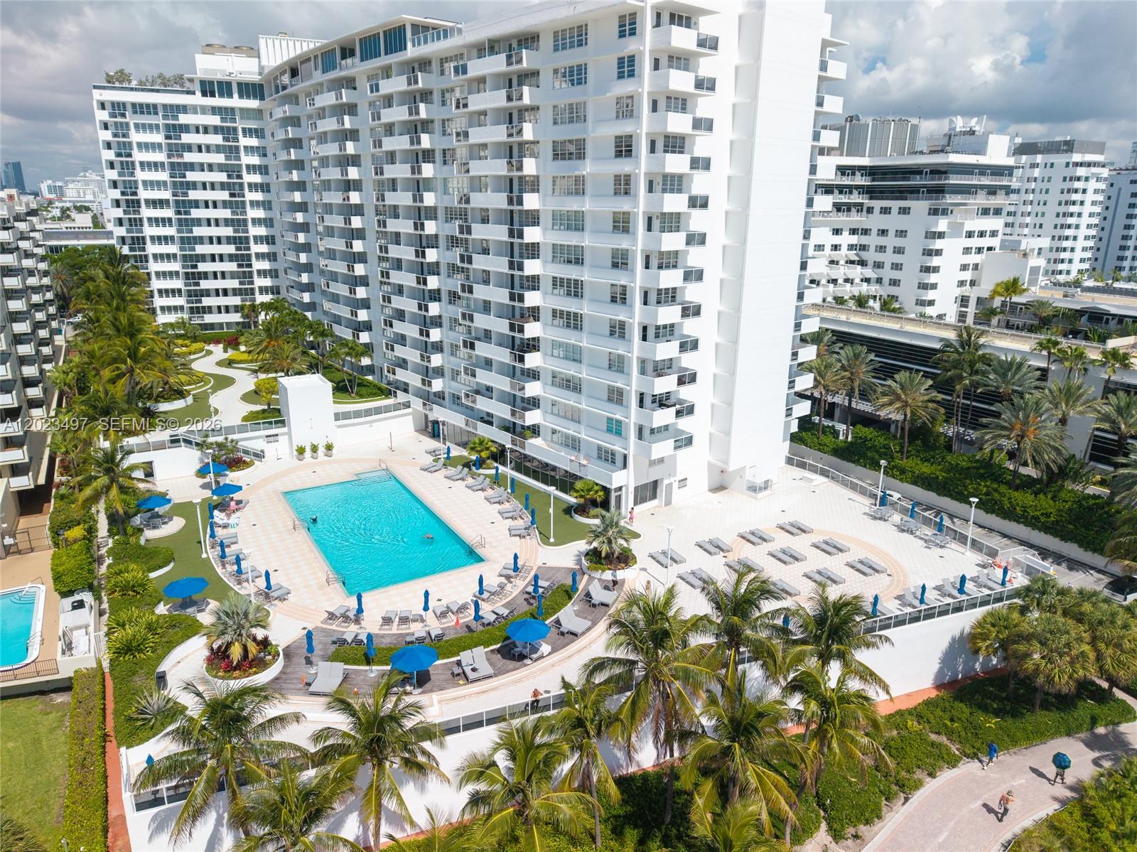 An aerial view shows a large apartment complex with a swimming pool and palm trees — 100 Lincoln Rd # 1523, Miami Beach FL 33139, MIAMI BEACH, FL