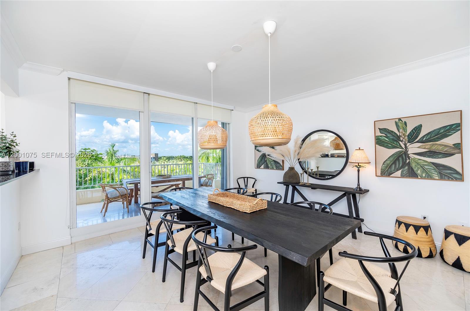 A dining room features a dark wood table, woven pendant lights, and a balcony view — 789 Crandon Blvd # 502, Key Biscayne FL 33149, KEY BISCAYNE, FL