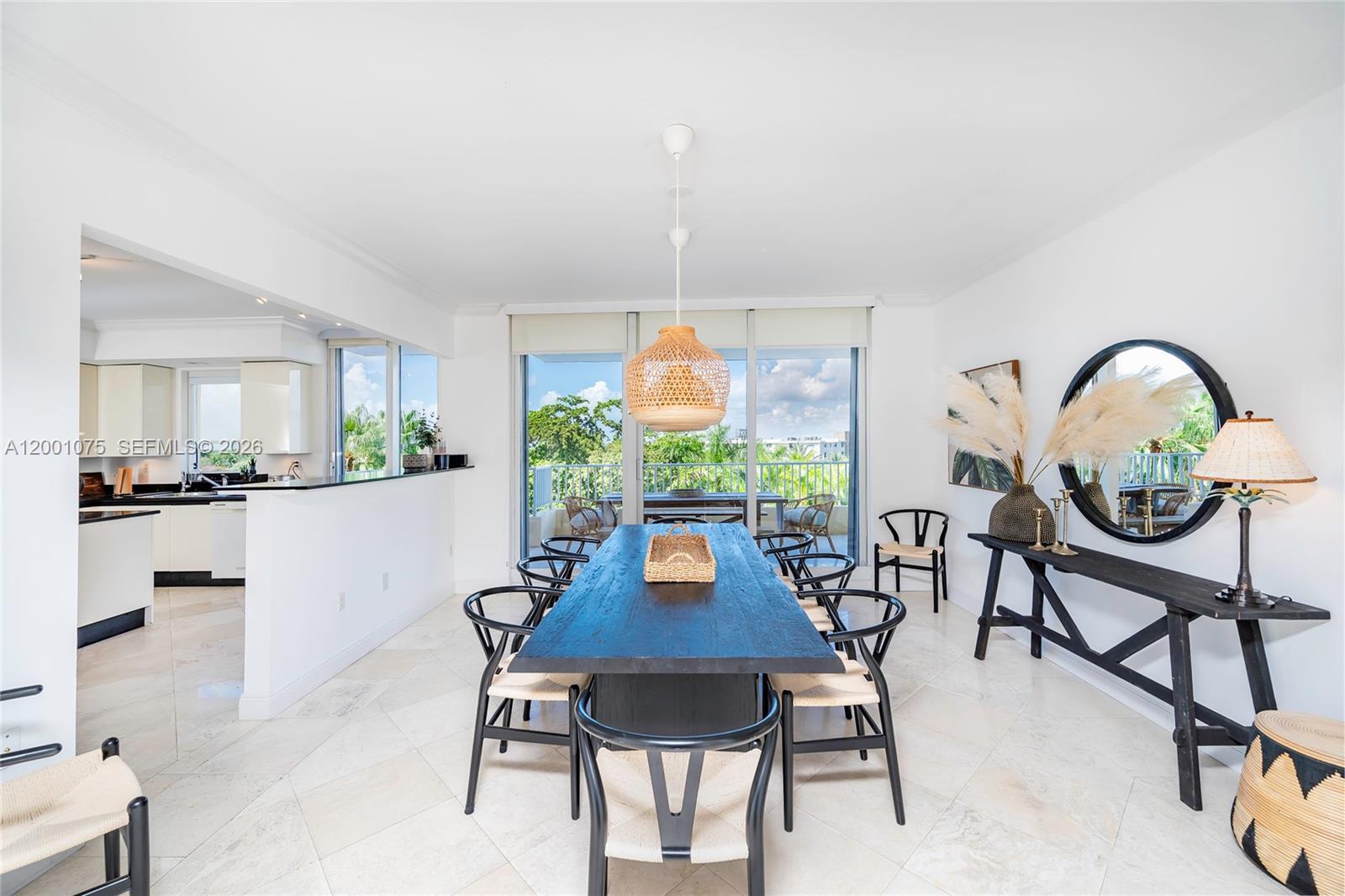 A dining room features a long black table, woven chairs, and a view of trees — 789 Crandon Blvd # 502, Key Biscayne FL 33149, KEY BISCAYNE, FL