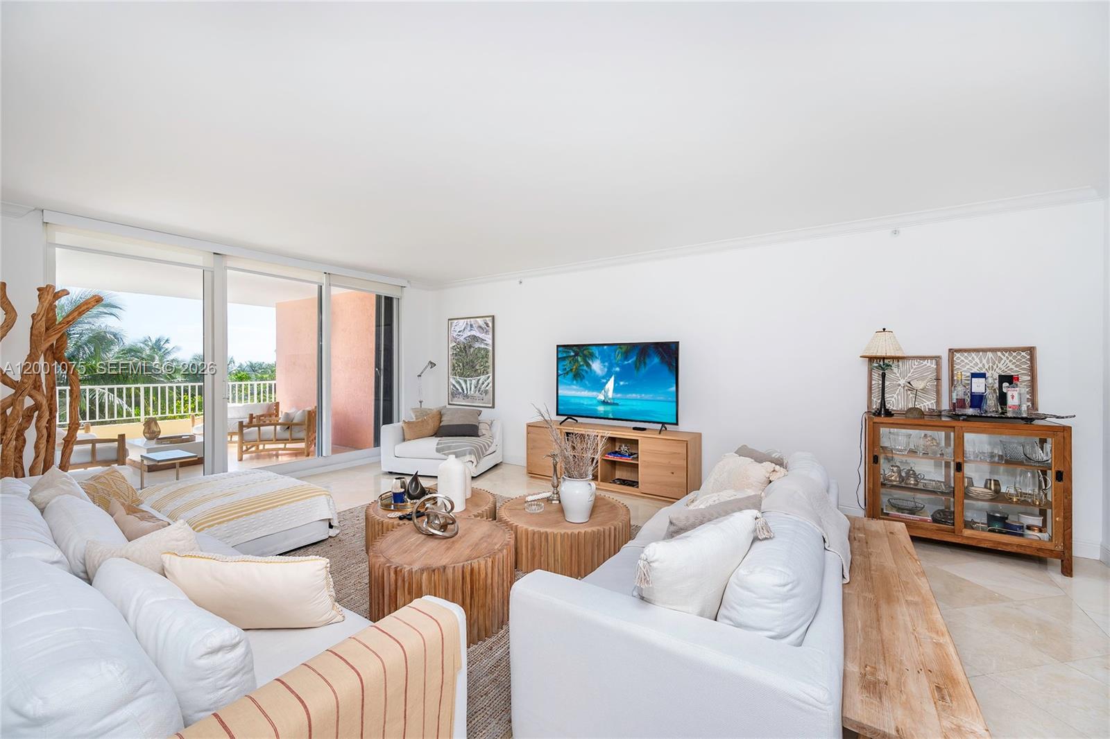 A bright living room features white sofas, wooden coffee tables, and a balcony with ocean views — 789 Crandon Blvd # 502, Key Biscayne FL 33149, KEY BISCAYNE, FL