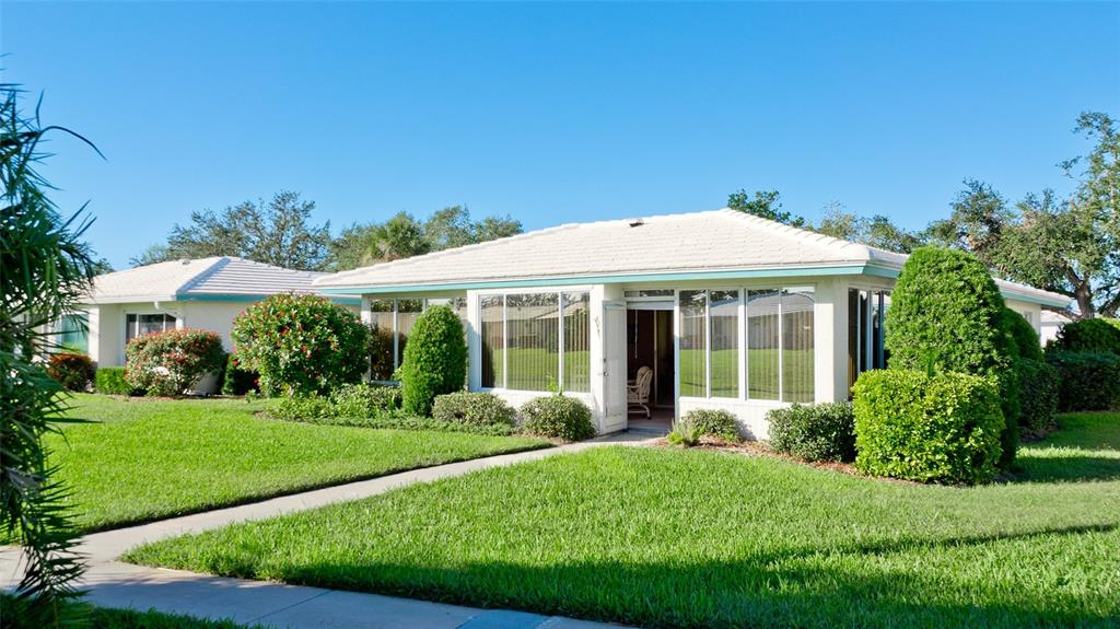 A single-story house with a white exterior, tiled roof, and a green lawn — 6809 9TH AVENUE W UNIT 523, BRADENTON, FL