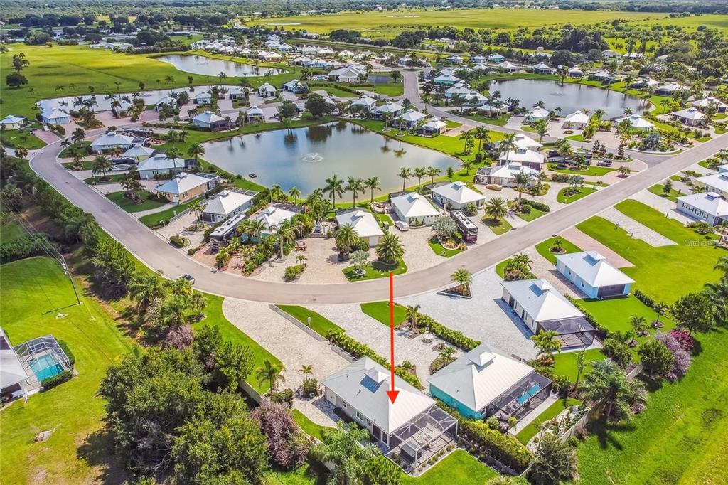 An aerial view shows a residential neighborhood with houses, a pond, and a red arrow — 8574 SW SAND CRANE - LOT 53 CIRCLE, ARCADIA, FL
