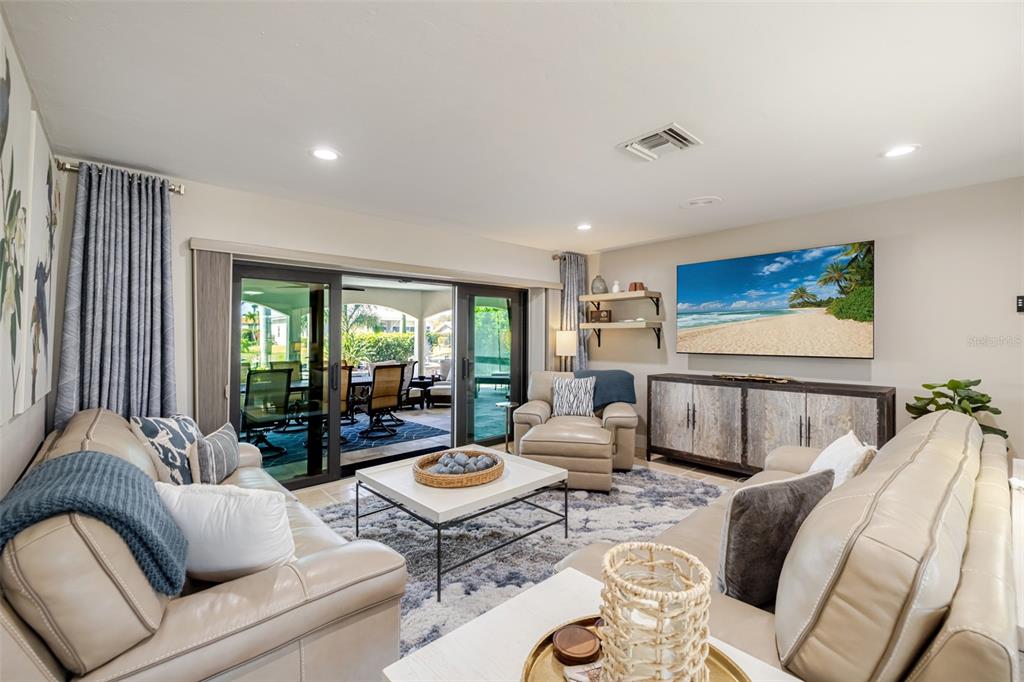 A living room features light leather sofas, a coffee table, and sliding doors to a patio — 6777 DANAH COURT, FORT MYERS, FL
