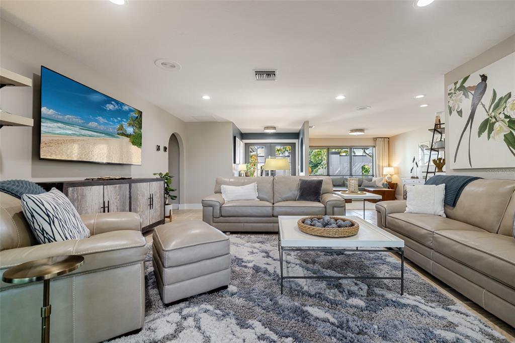 A living room features light leather sofas, a patterned area rug, and a wall-mounted television — 6777 DANAH COURT, FORT MYERS, FL