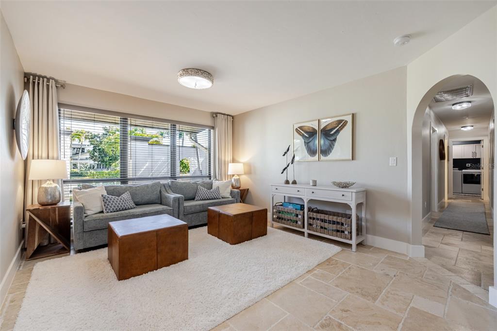 A living room features a gray sofa, two leather ottomans, and a white console table — 6777 DANAH COURT, FORT MYERS, FL