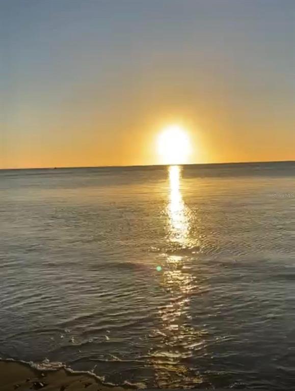 A bright sun sets over the calm ocean water viewed from a sandy beach — PR 3301 KM 2.6 INT PUNTA MELONES, BOQUERON, CABO ROJO, PR