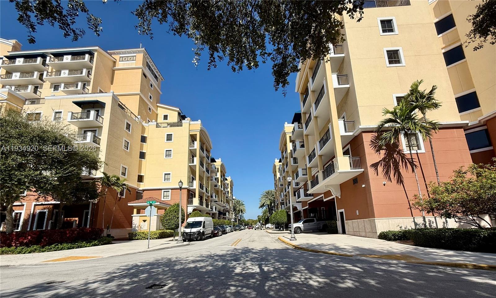 A street view of two multi-story apartment buildings with balconies under a clear blue sky — 8395 SW 73rd Ave # 417, Miami FL 33143, MIAMI, FL