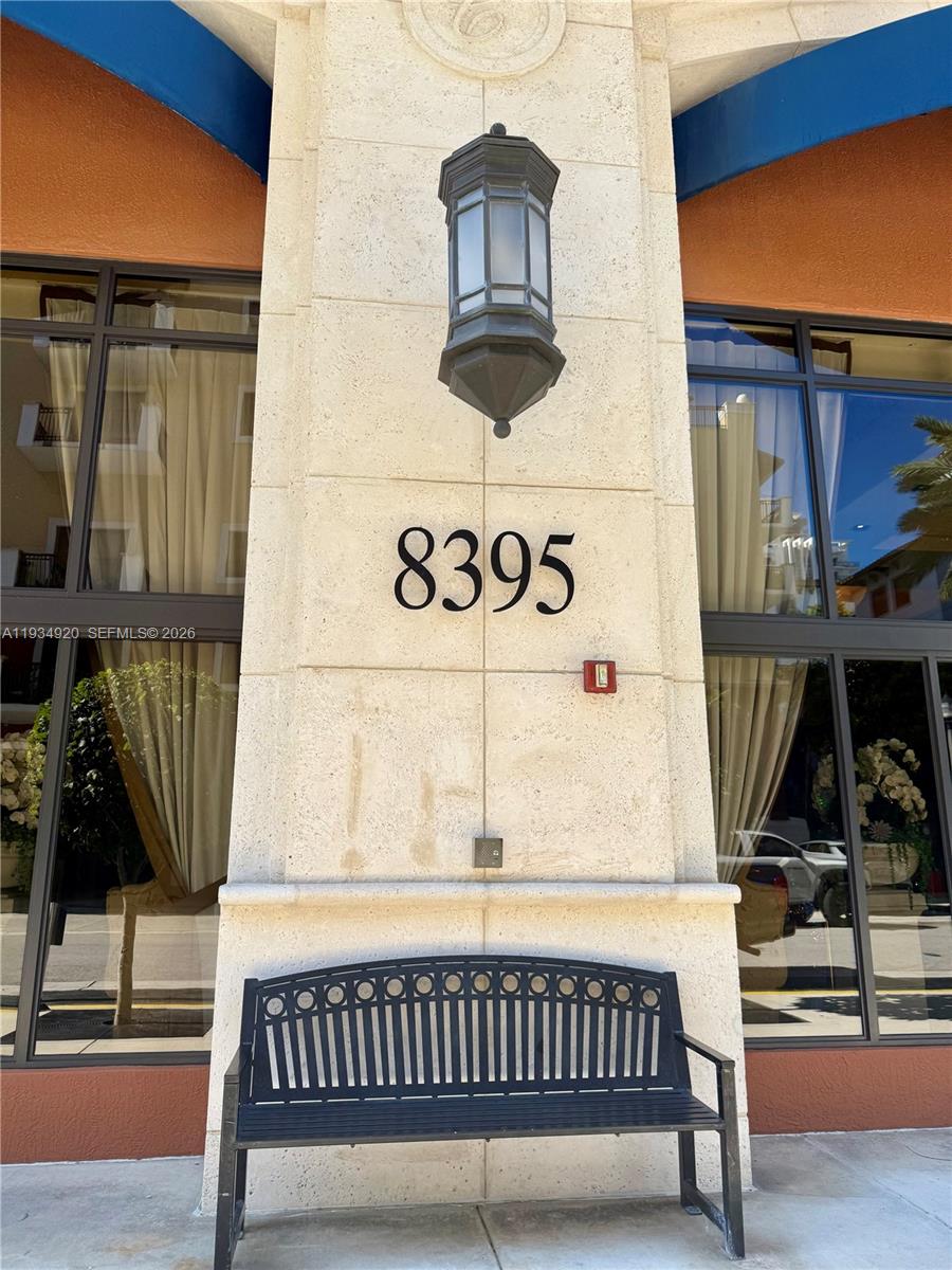 A black metal bench sits in front of a stone pillar displaying the number 8395 — 8395 SW 73rd Ave # 417, Miami FL 33143, MIAMI, FL