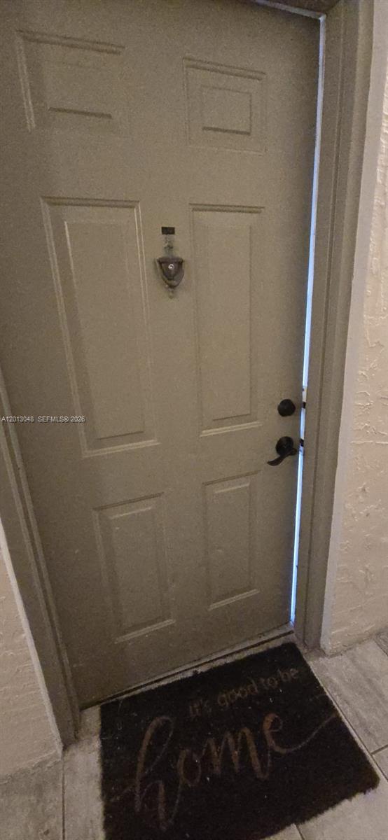 A beige front door with a door knocker and a welcome mat on the floor — 8240 SW 210th St # 214, Cutler Bay FL 33189, CUTLER BAY, FL