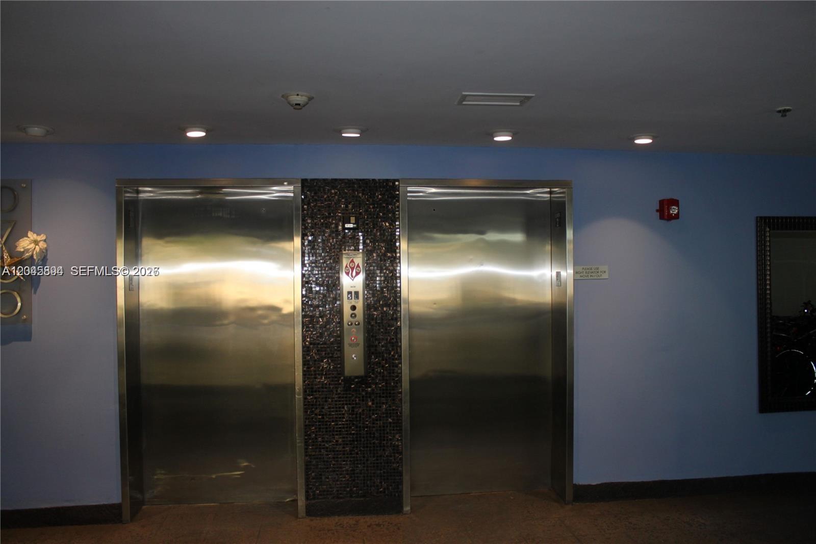 Two stainless steel elevator doors are set into a wall with a tiled center panel — 700 NE 63rd St, Miami FL 33138, MIAMI, FL