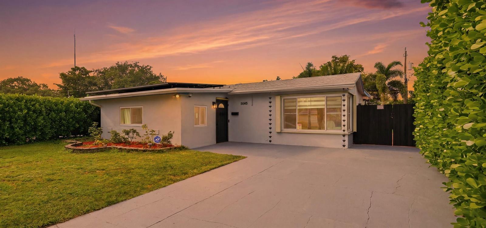 A single-story house with a gray exterior, a front lawn, and a paved driveway — 6448 Custer Street, Hollywood FL 33024, HOLLYWOOD, FL
