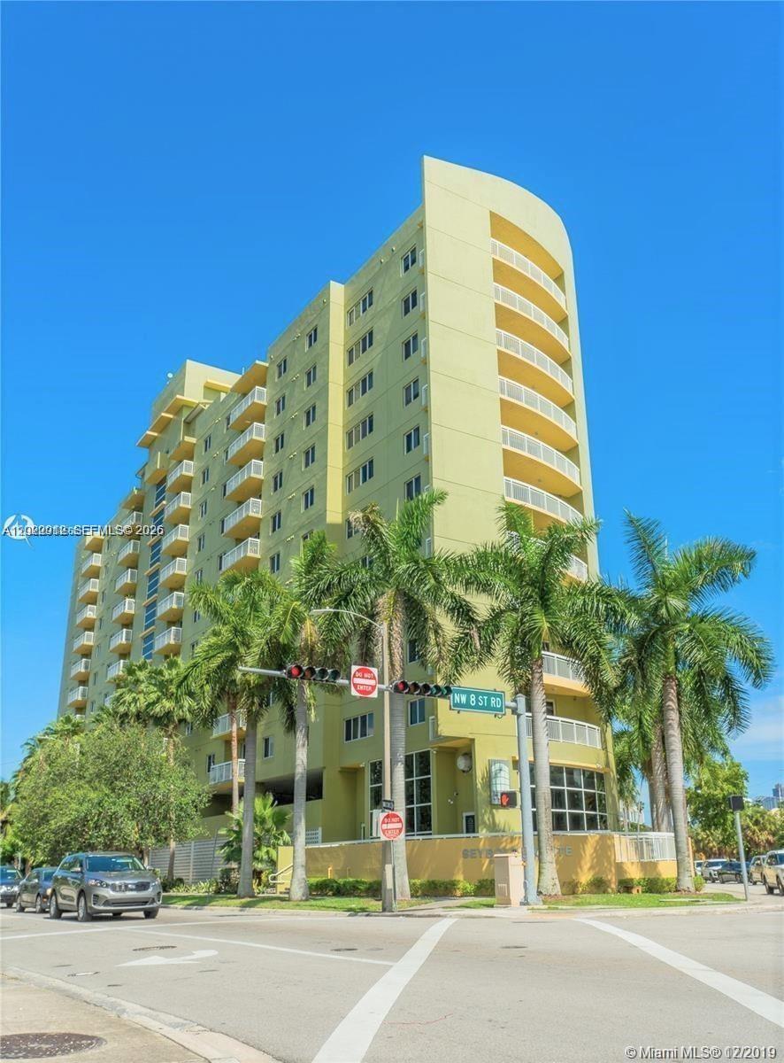 A tall, light-green apartment building stands at a street corner with palm trees in front — 816 NW 11th St # 801, Miami FL 33136, MIAMI, FL