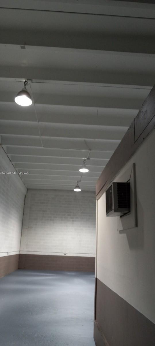 An interior view of a warehouse space with white walls, exposed ceiling beams, and pendant lighting — 2067 W 62nd St, Hialeah FL 33016, HIALEAH, FL