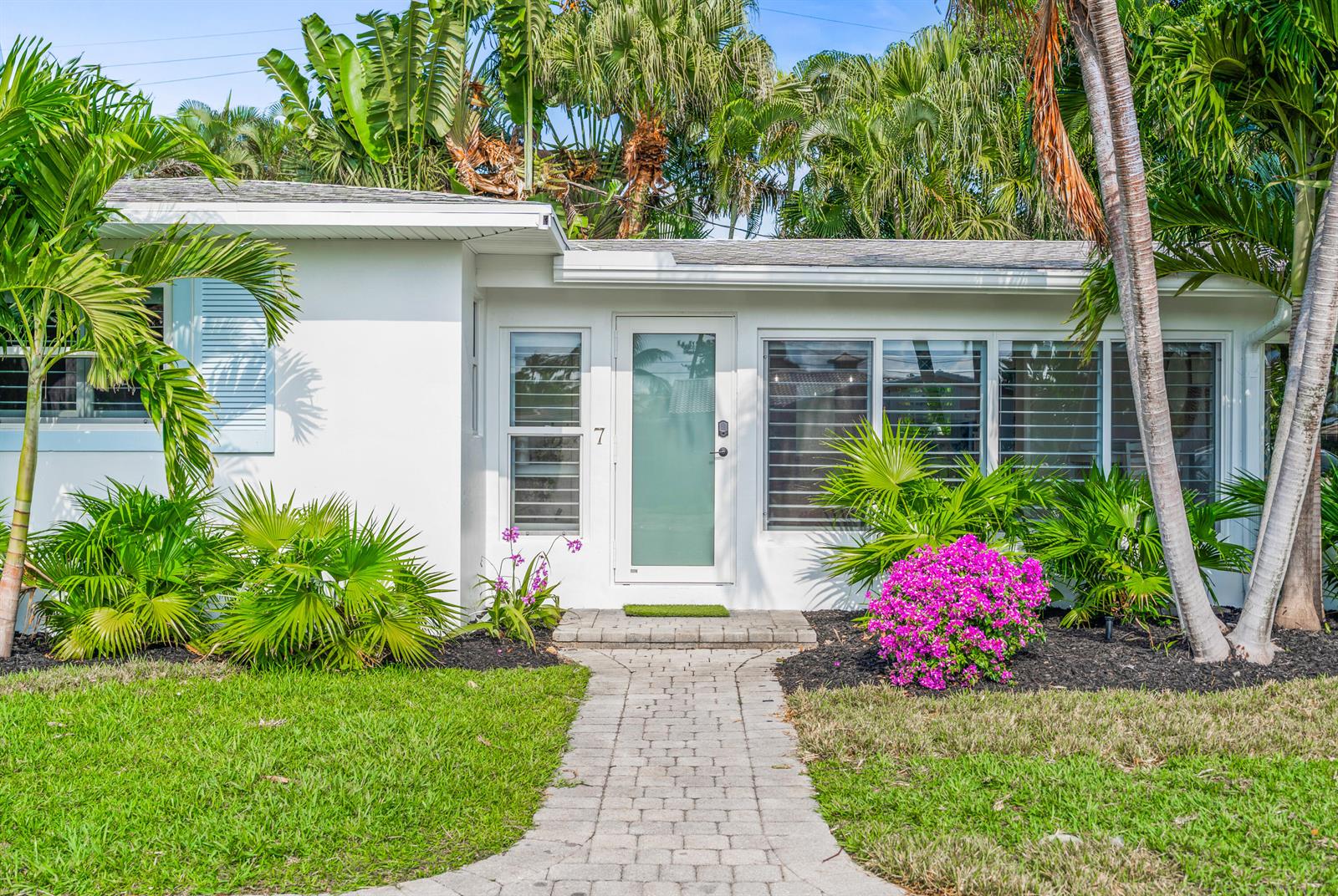 A white single-story house with a paved walkway, palm trees, and a front door — 7 Fayette Drive, Ocean Ridge FL 33435, OCEAN RIDGE, FL