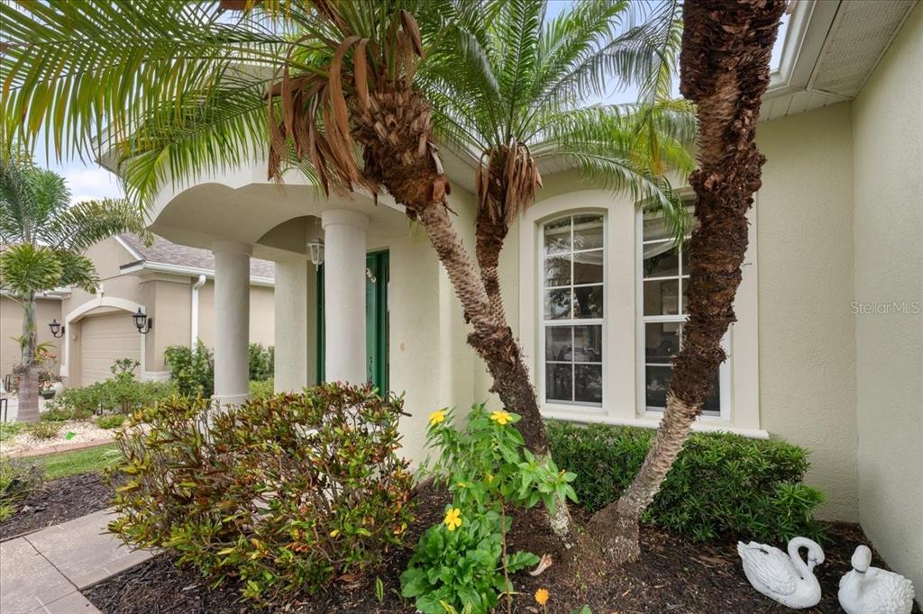 The exterior of a house features a palm tree, a front porch, and windows — 11409 56TH STREET CIRCLE E, PARRISH, FL