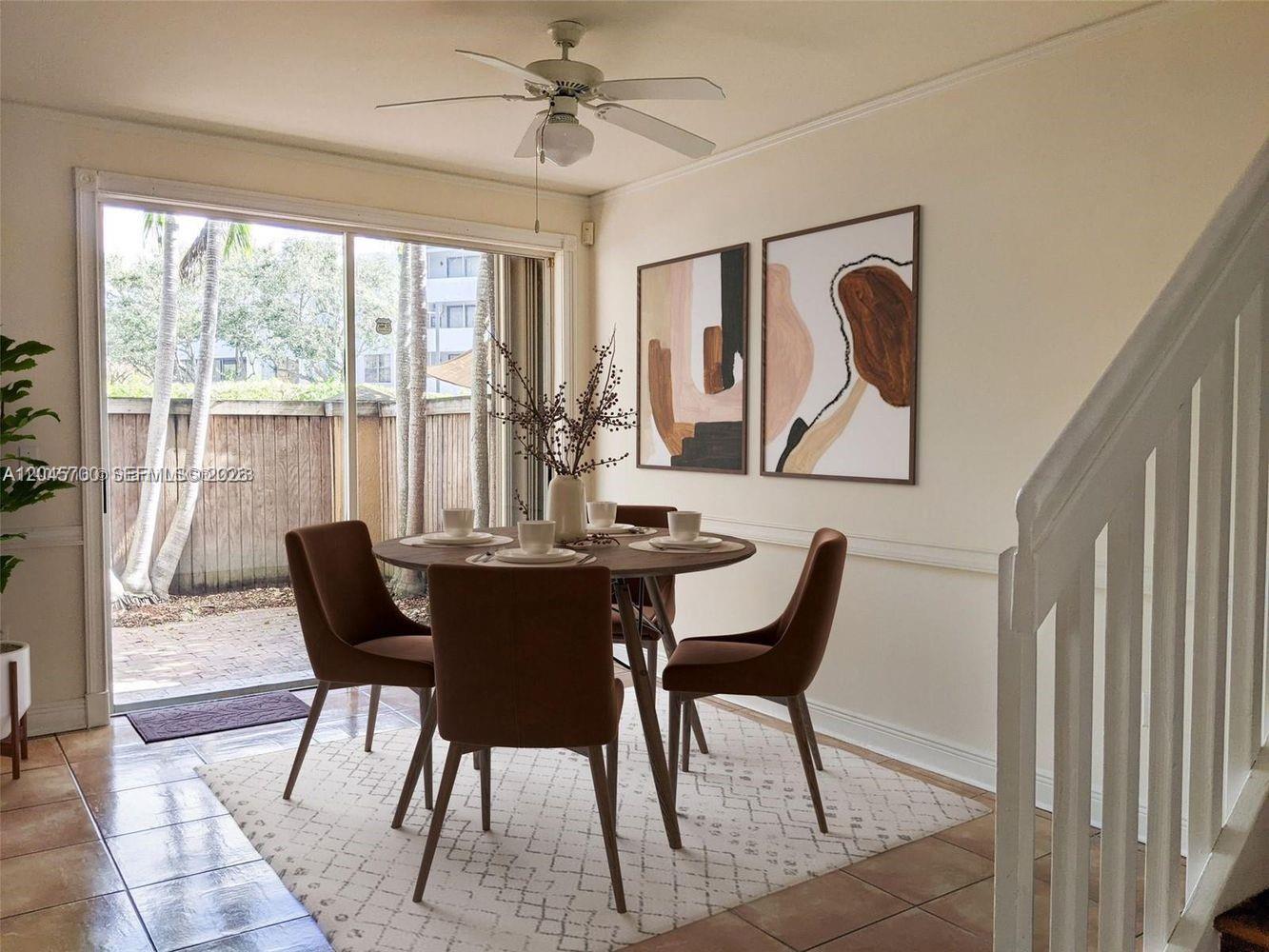 A dining area features a round table, four chairs, abstract wall art, and a sliding door — 8853 SW 108th Pl, Miami FL 33176, MIAMI, FL