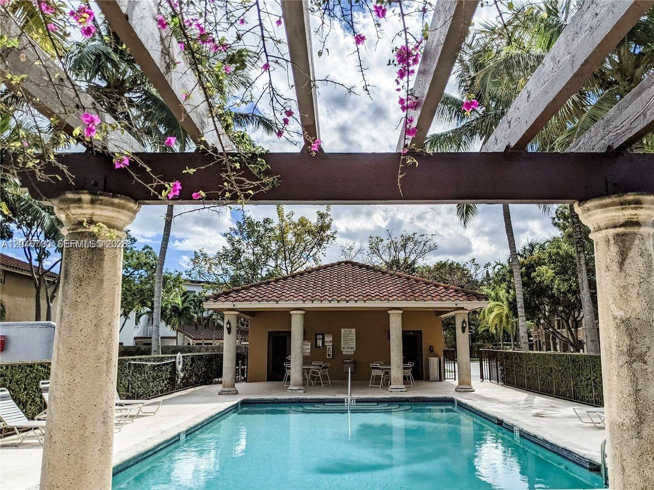 A swimming pool sits in front of a small building under a wooden pergola — 8853 SW 108th Pl, Miami FL 33176, MIAMI, FL