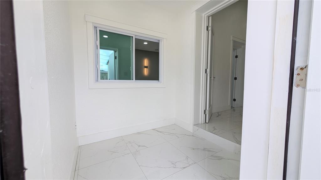 A small room with white walls, a window, and white marble-patterned tile flooring — 1245 N PINE HILLS ROAD, ORLANDO, FL