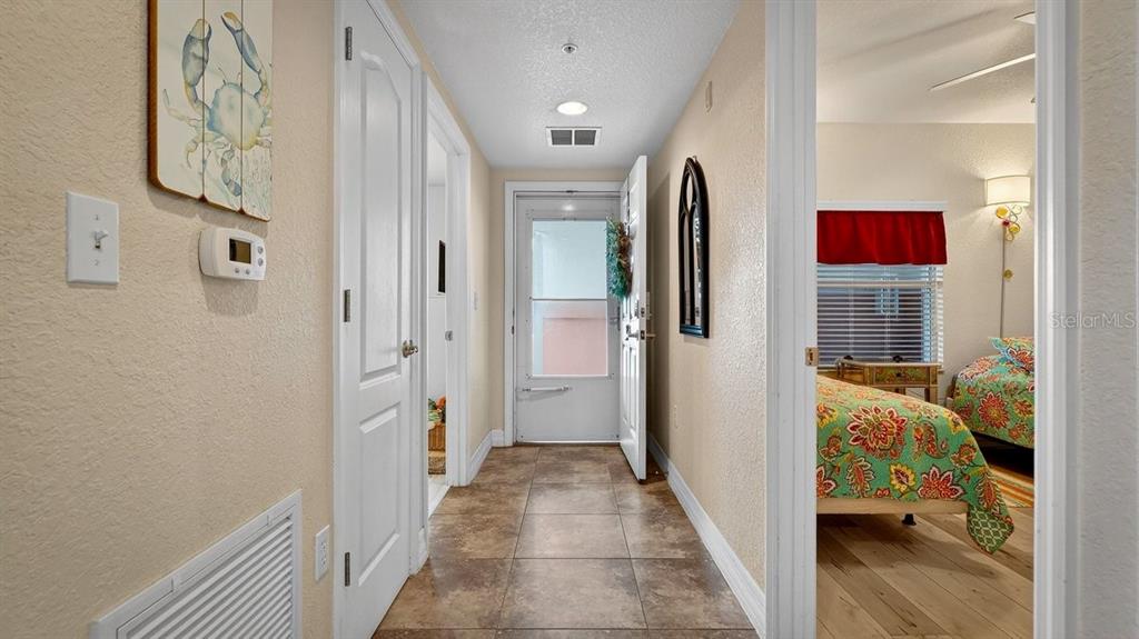 A tiled hallway leads to an exterior door, with a bedroom visible to the right — 5300 S ATLANTIC AVENUE UNIT 19-203, NEW SMYRNA BEACH, FL
