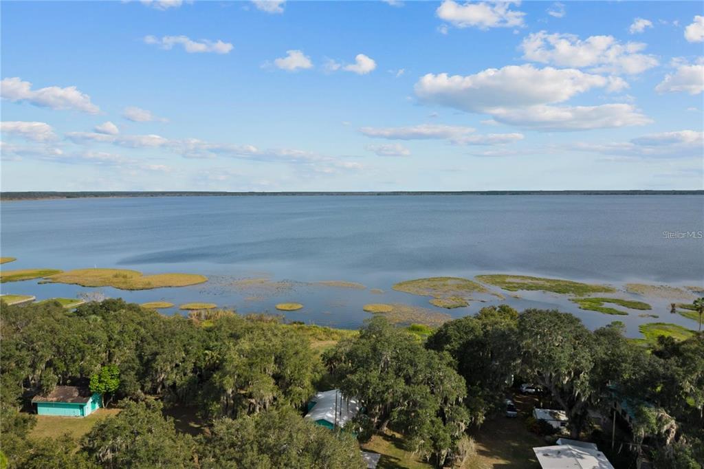 An aerial view shows a lakefront property with trees and several small houses — BEACH PARKWAY, LAKE WALES, FL