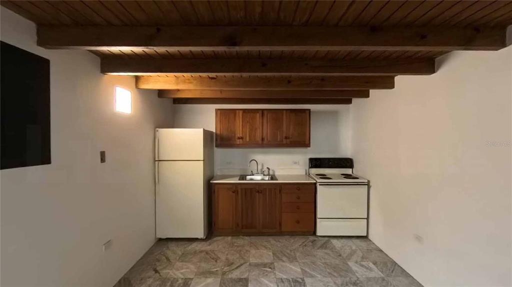 A kitchen features wood cabinets, white appliances, and exposed wooden ceiling beams — 152 SAN JUSTO STREET, SAN JUAN, PR