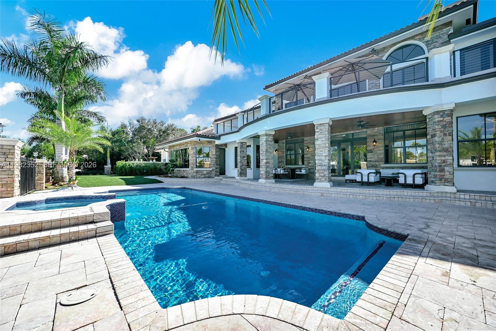 A two-story house with a stone facade, a swimming pool, and a covered patio — 2905 Paddock Rd, Weston FL 33331, WESTON, FL