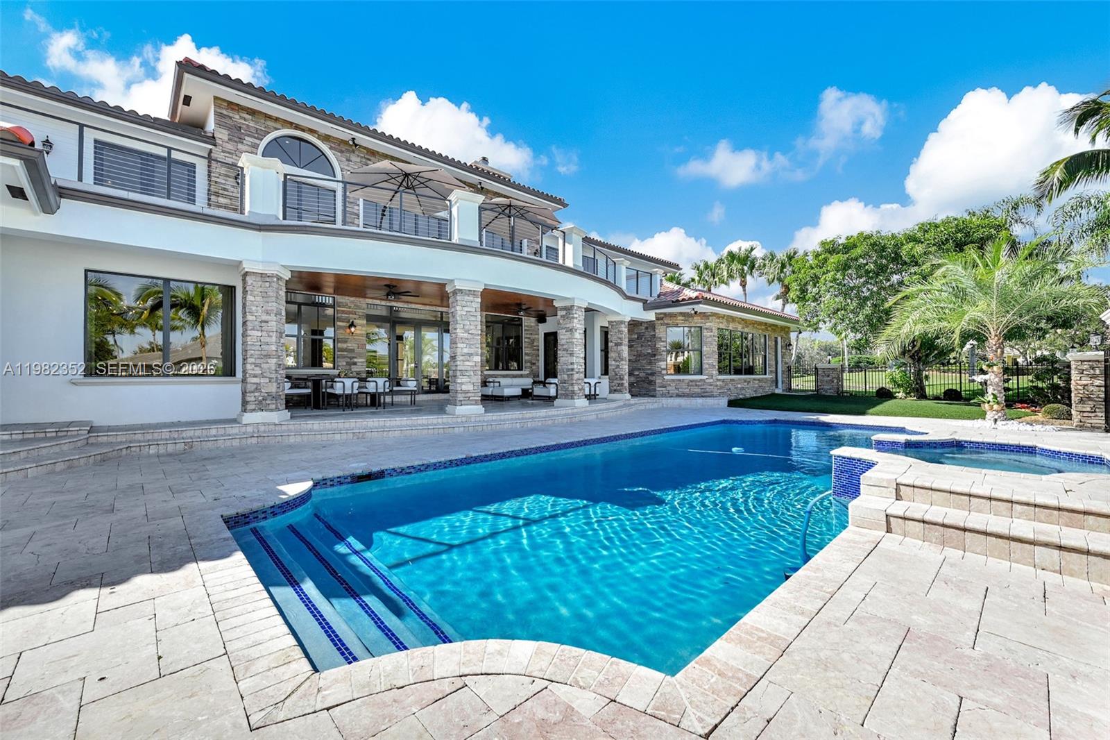 A two-story house with a stone facade, covered patio, and a swimming pool — 2905 Paddock Rd, Weston FL 33331, WESTON, FL